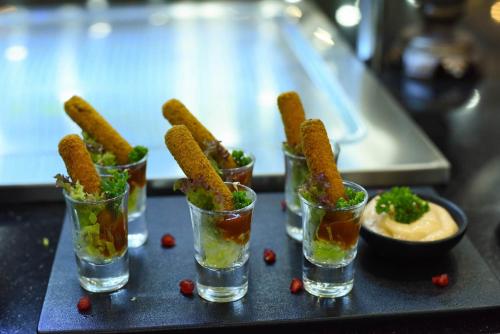 a group of four glasses filled with food and a bowl of dips at Horizon Manor Hotel in Doha