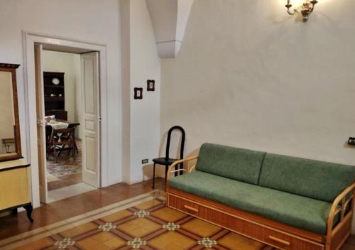 a living room with a green couch and a table at Antica Via delle Aie in Ruffano
