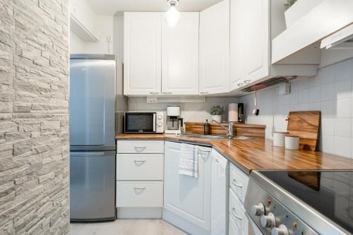 a kitchen with white cabinets and a blue refrigerator at 2ndhomes Tampere "Pieni Verka" Apartment - Superior Downtown Apt Near Restaurants in Tampere