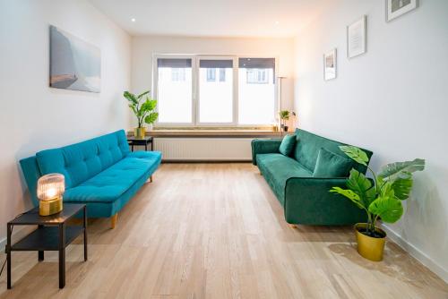 un soggiorno con 2 divani blu e un tavolo di Charming Central Cityflats ad Anversa