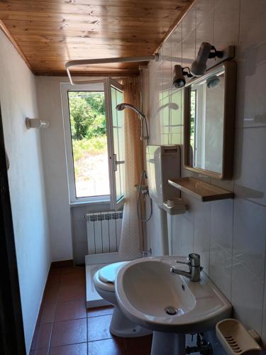 a bathroom with a sink and a toilet and a window at CASA GIANNI citra 011008 LT 0014 in Pegui