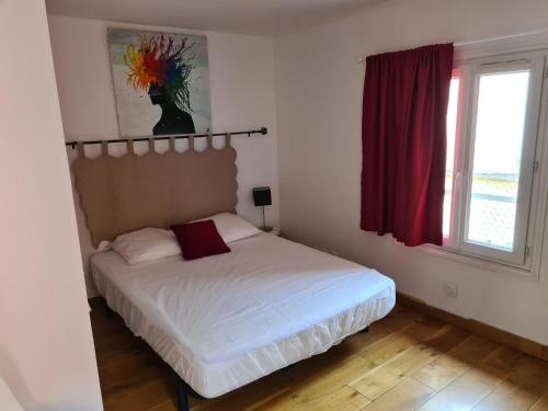 - une chambre avec un lit blanc et un rideau rouge dans l'établissement La tropezienne, Duplex 73 m2, 100 m du port, climatisation, grande terrasse, à Sanary-sur-Mer