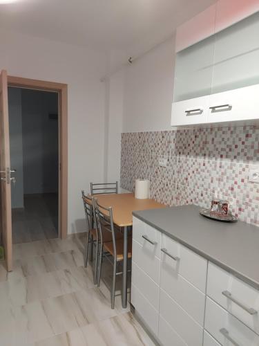 a kitchen with a table and chairs in a room at BYA BROWN in Valea Lupului
