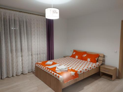 a bedroom with a bed with orange pillows at BYA BROWN in Valea Lupului