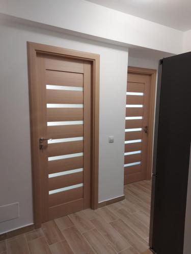 two wooden doors in a room with wooden floors at BYA BROWN in Valea Lupului