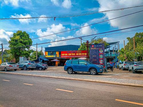 a parking lot with cars parked in front of a building at Khách sạn Vườn Cau & Khu vui chơi giải trí SaLa in Tây Ninh