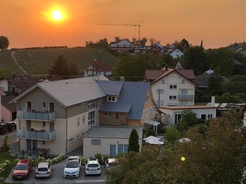 eine Gruppe von Häusern und Autos, die auf einem Parkplatz geparkt sind in der Unterkunft Seebrise mit Musik und Wein in Meersburg