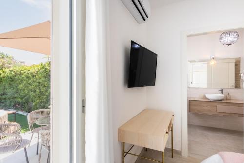 a living room with a table and a tv on a wall at Panarea 22 in Calabernardo
