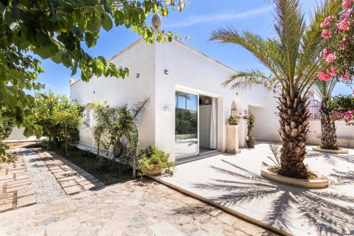 a villa with a courtyard with palm trees at Panarea 22 in Calabernardo