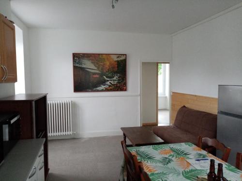 ein Wohnzimmer mit einem Sofa und einem Tisch in der Unterkunft gite du ruisseau in Murat-sur-Vèbre