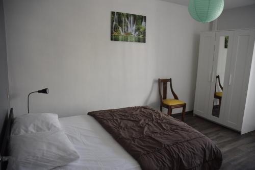 a bedroom with a bed with a blanket on it at Appart-alma in Saint-Laurent-sur-Sèvre