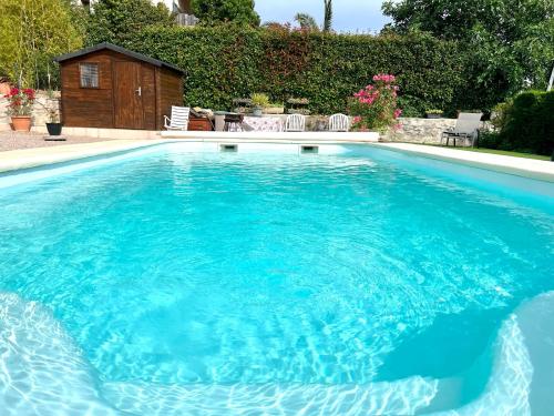 a large pool with blue water in a yard at Villa Chante Grive in Taradeau