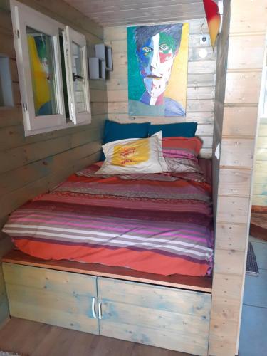 a bed in a tiny house with a window at Roulotte au numero 886 in Salernes