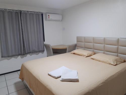 a bedroom with a large bed with two towels on it at Porto de Iracema in Fortaleza