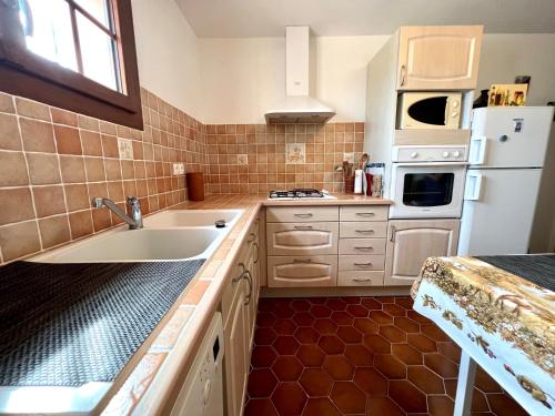 a kitchen with a sink and a white refrigerator at Villa Chante Grive in Taradeau