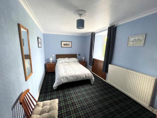 una camera blu con un letto e un divano di Pass the Keys Spacious 3BR Cottage in Beautiful Rural Setting a Castle Douglas