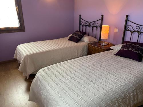 2 letti in una camera con pareti viola di RINCÓN DE DORA a La Pesa