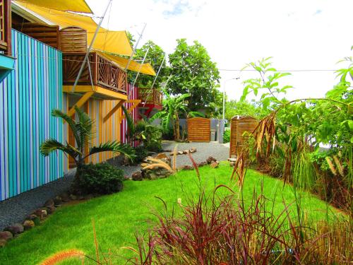 un jardín frente a una casa con césped verde en Katalo Plage en Deshaies
