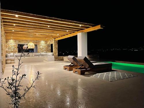 a living room with couches and a pool at night at Voras Villa Panagia Beach in Antiparos