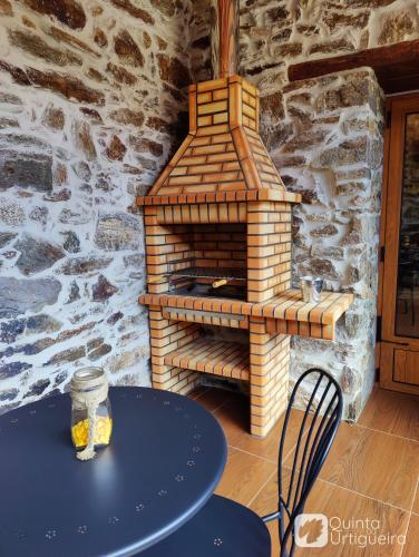 a table with a brick oven in a room at Quinta da Urtigueira in Felgueiras