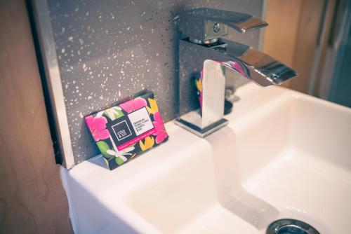 ein Waschbecken mit einem Wasserhahn und einer Zahnpasta in der Unterkunft Empress En Suite Wagon in Arthog