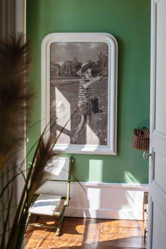 a painting of a child on a green wall at Hôtel Restaurant de Bouilhac in Montignac