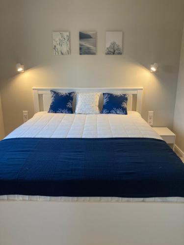 a blue and white bed in a bedroom at Rizling Apartmanház**** Balatonalmádi in Balatonalmádi