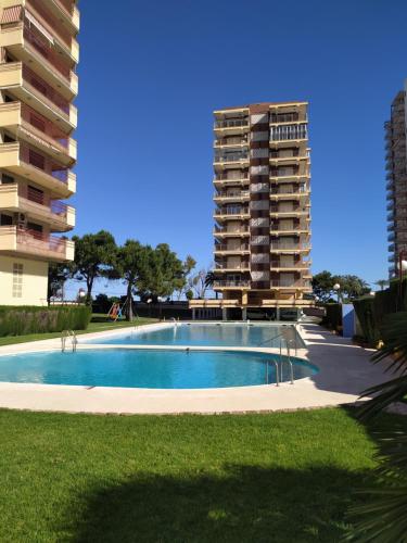 a swimming pool in front of a tall apartment building at BALI APARTMENT in Benicàssim