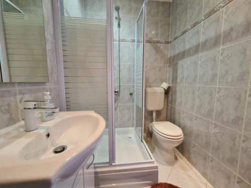 een badkamer met een douche, een wastafel en een toilet bij Joy in Zadar