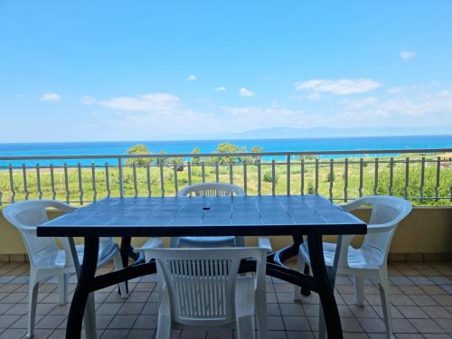 a blue table and chairs on a balcony with the ocean at Beverley Apartment - FAMILY Residence in Briatico