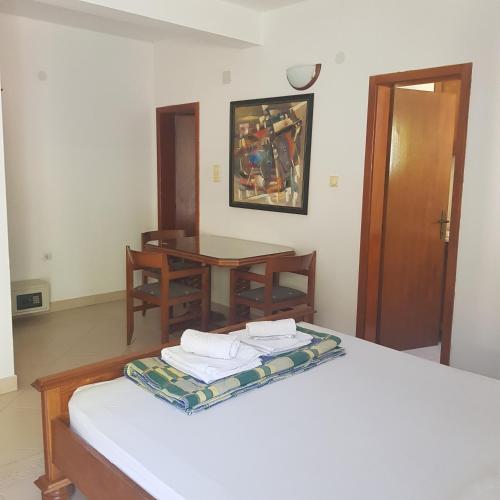 a room with a bed and a table with towels on it at Vila Horizont in Sveti Stefan