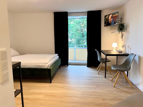 a bedroom with a bed and a desk and a window at Ferienwohnung Washingtonweg in Hannover