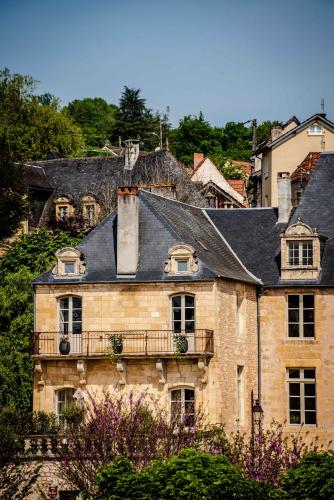 an old stone house with a balcony on a hill at Hôtel Restaurant de Bouilhac in Montignac