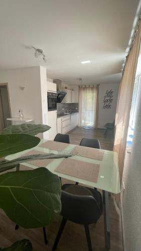 a dining room with tables and chairs and a kitchen at Seebrise mit Musik und Wein in Meersburg