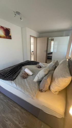 a large bed with pillows on it in a room at Seebrise mit Musik und Wein in Meersburg