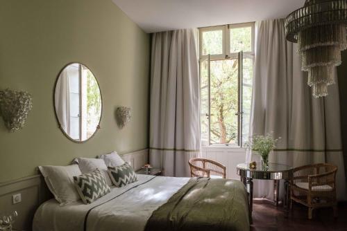 a bedroom with a bed and a table and a window at Hôtel Restaurant de Bouilhac in Montignac