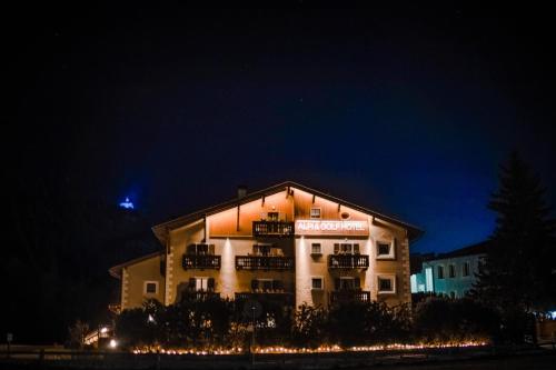 a building with a sign on it at night at Alpi & Golf Hotel in Bormio