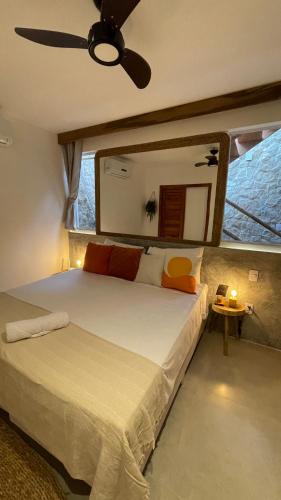 a bedroom with a large bed with a ceiling fan at Piticcaia Lodge - Casa pé na areia, Frente mar - PREÁ in Prea