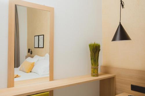 a mirror on a shelf with a bed in a room at Essentia Vita Comfy Suites in Limenas