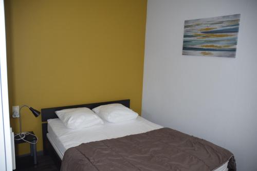 a bedroom with a bed with two white pillows at Appart-alma in Saint-Laurent-sur-Sèvre