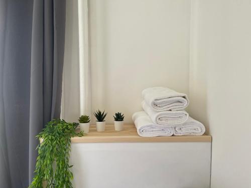 a pile of towels sitting on a shelf in a bathroom at Patchouli Le Havre appartement 100m2, plage à 500m !! in Le Havre