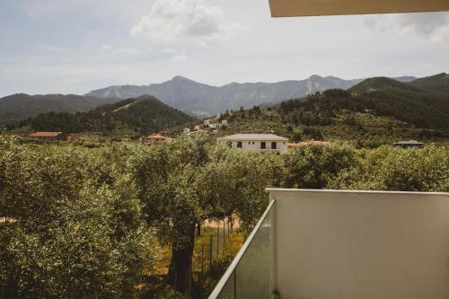 a view from the balcony of a house with trees and mountains at Essentia Vita Comfy Suites in Limenas