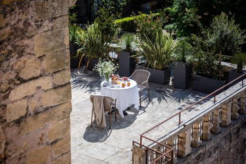a table and chairs on a patio with plants at Hôtel Restaurant de Bouilhac in Montignac