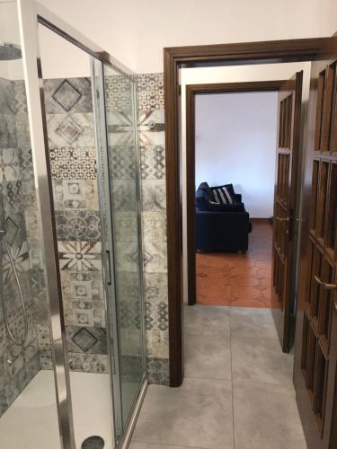 - Ducha a ras de suelo con puerta de cristal en una habitación en Appartamento vicino Rho Fiera, en Cornaredo