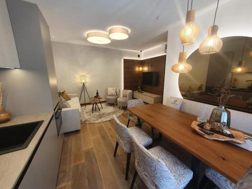 a kitchen and living room with a wooden table and chairs at Sibenbras Natural Aparthotel in Limone sul Garda