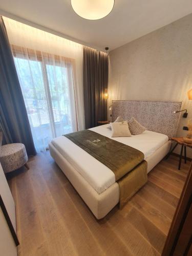 a bedroom with a large bed and a large window at Sibenbras Natural Aparthotel in Limone sul Garda