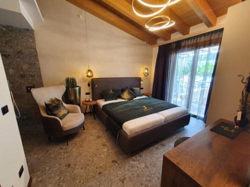 a bedroom with a bed and a couch and a chair at Sibenbras Natural Aparthotel in Limone sul Garda