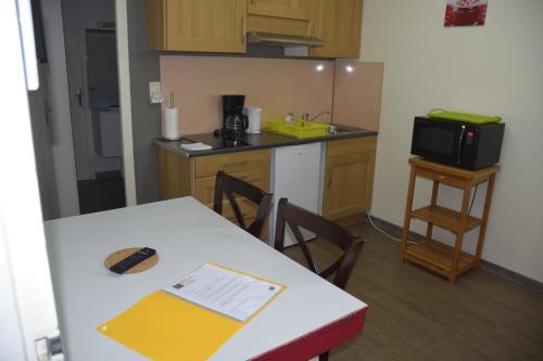a small kitchen with a table and a microwave at Appart-alma in Saint-Laurent-sur-Sèvre