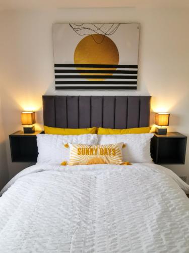 a bedroom with a large white bed with two lamps at Bee At Home in Cefn-coed-y-cymmer