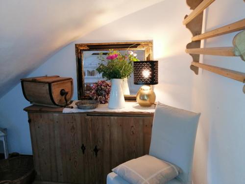 a mirror and a vase with flowers on a dresser at Freundsheimhof in Kramsach